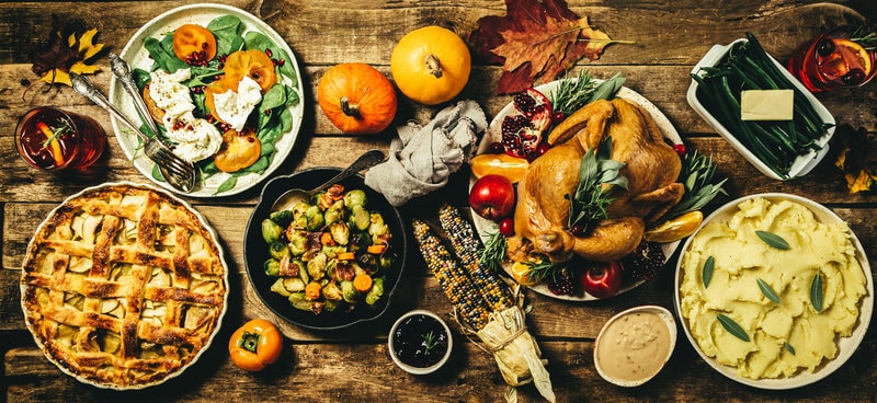 Selection of Thanksgiving foods on a wooden table.