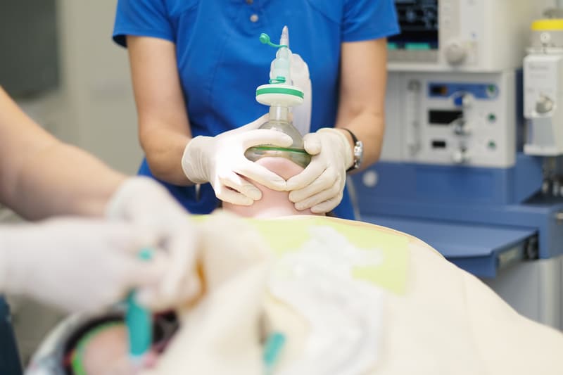A dental patient laying in a chair receiving dental sedation for a procedure.
