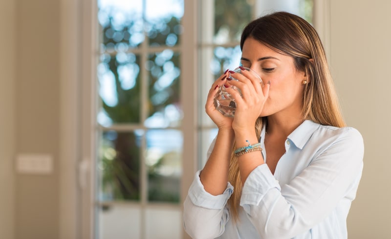 Young woman drinking a glass of water